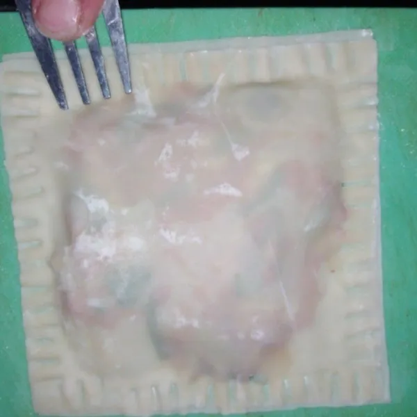 Tutup dengan 1 lembar kulit pangsit. Rekatkan tepinya dengan air dan tekan-tekan menggunakan garpu.