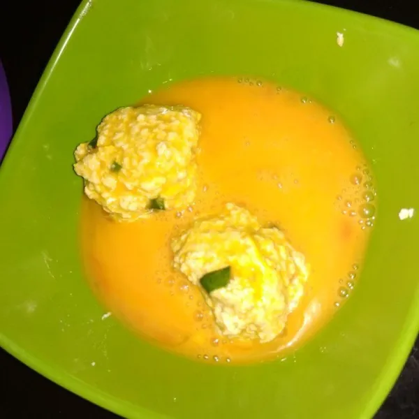 Kocok lepas telur, ambil segenggam adonan tahu lalu bentuk seperti bola. Celupkan ke dalam kocokan telur.