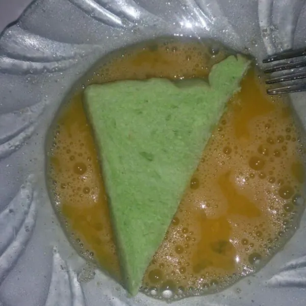 Potong roti tawar sesuai selera, lalu celupkan pada adonan telur. Bolak balik ya semua sisi roti.