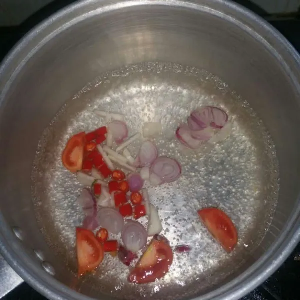 Didihkan air, masukkan bawang merah, bawang putih, cabe merah, dan tomat. Masak sampai tomat setengah matang.
