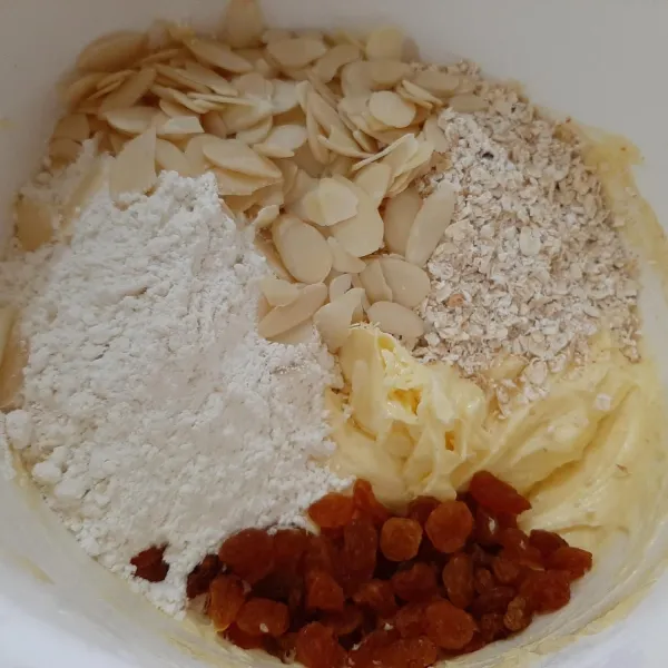 Masukkan tepung terigu, oatmeal, almond, dan raisin, aduk rata hingga adonan dapat dibentuk.