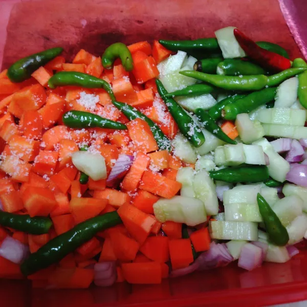 Masukkan wortel, ketimun, cabai, dan bawang di sebuah kontainer / wadah bertutup. Taburi garam, remas sedikit.