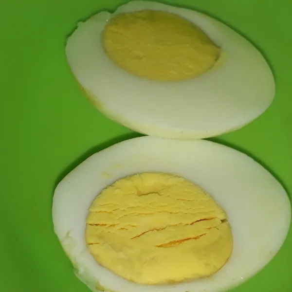 Belah dua telur yang sudah direbus.