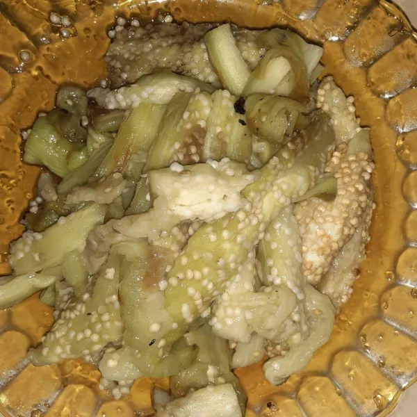 Selagi terong masih panas, ambil dagingnya dari kulitnya.