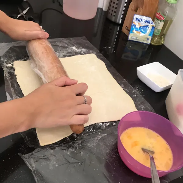 Giling sedikit pastry puff dan beri tepung diatas bawah supaya tidak lengket.