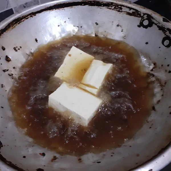 Iris tahu putih menjadi tiga bagian kemudian goreng sampai matang.