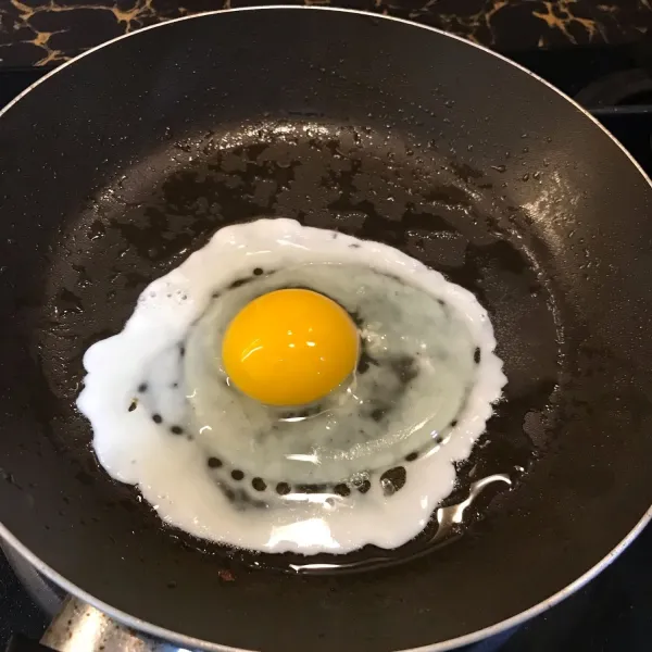 Masak telur mata sapi lalu taburi black pepper dan garam. Jika sudah matang, angkat dan sisihkan.