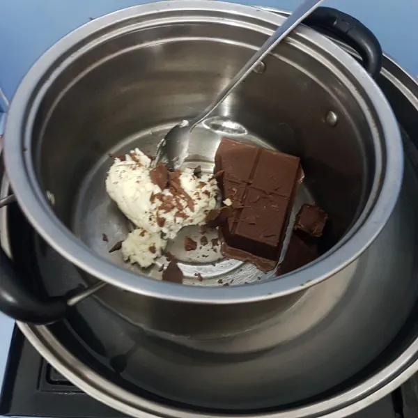 Panaskan air dalam panci, lelehkan coklat batang dan cream oreo yang tersisa. Jangan sampai masuk air ke dalamnya.