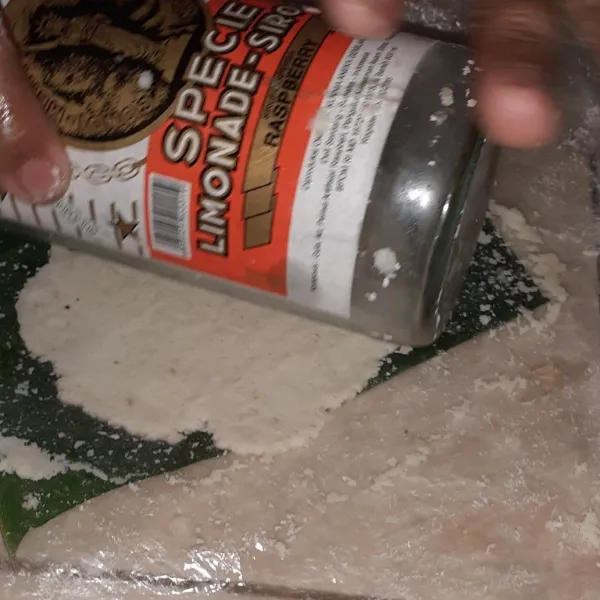Letakkan adonan diatas daun pisang yang sudah diolesi minyak, lalu tutup dengan plastik dan pipihkan dengan botol.