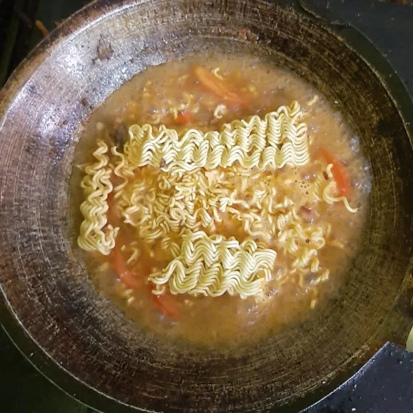 Masukan mie instan beserta bumbu mie, gula dan garam.