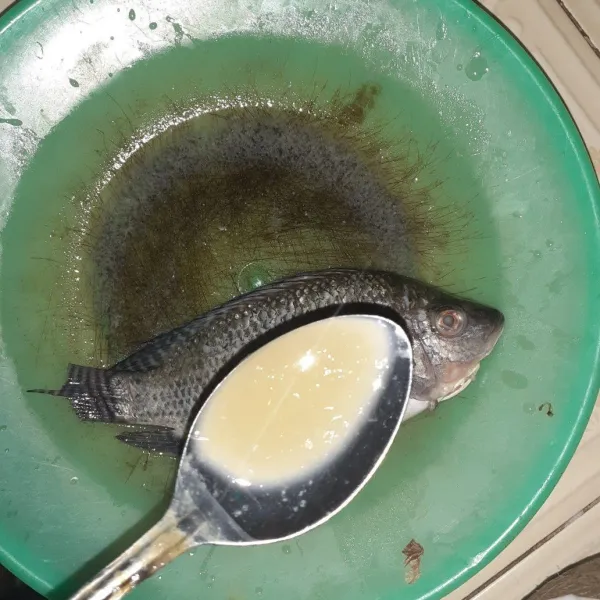 Bersihkan ikan nila, lumuri dengan air lemon dan garam.