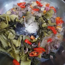 Kemudian masukkan sawi asin, gula pasir, merica bubuk, kaldu jamur bubuk, dan air. Aduk hingga rata.