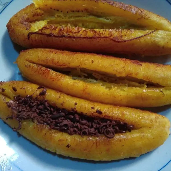 Kerat pisang memanjang tapi jangan tembus sampai bawah. Isi dengan coklat parut secukupnya, lakukan ketika pisang masih panas supaya coklat meleleh. Lakukan hingga selesai.