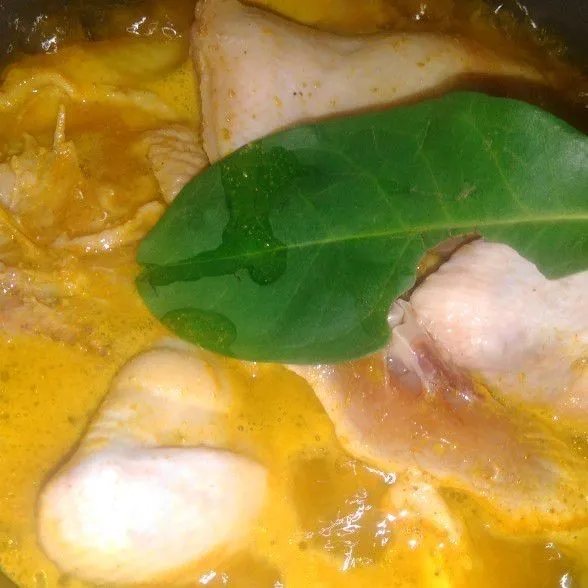 Masukkan ayam ke dalam wajan, air, bumbu instan ayam goreng, daun salam, serai lengkuas, garam, dan lada kemudian ungkep hingga meresap.