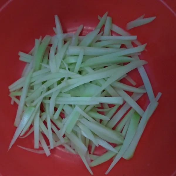 Iris-iris memanjang labu Siam, cuci sampai bersih.