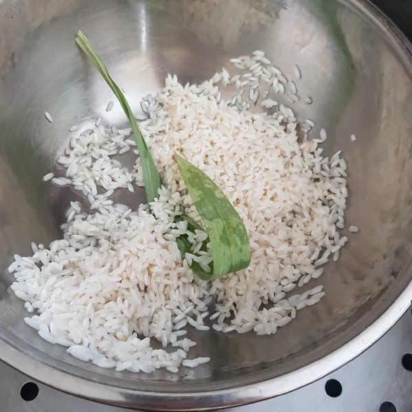 Rendam beras ketan selama 2 jam, kemudian cuci bersih, tambahkan daun pandan, aduk rata. Kukus dalam kukusan panas hingga beras ketan setengah matang.