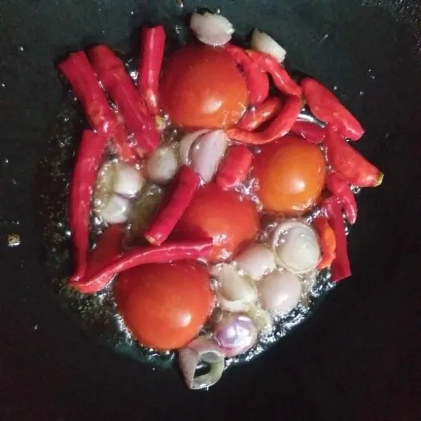Tumis bawang merah, cabai merah, cabai rawit, dan tomat sampai layu. Angkat.