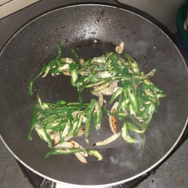 Masukkan bawang putih yang sudah dicincang dan irisan cabai hijau.