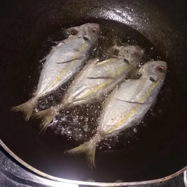 Goreng ikan yang sudah diberi garam dan masak sampai matang.