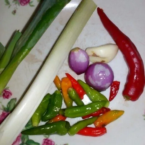 Potong kecil-kecil 15 cabe rawit, 1 cabe merah, 2 siung bawang merah, 1 siung bawang putih dan 2 lembar daun bawang.