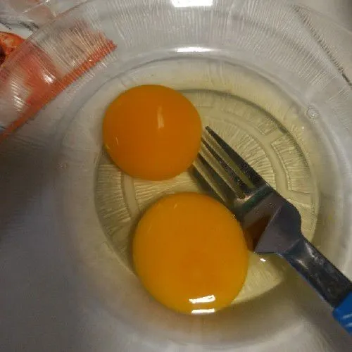 Siapkan 2 butir telur, kocok lepas.