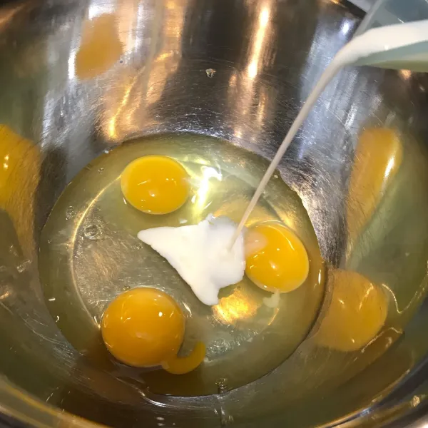 Masukkan telur kedalam wadah, lalu tuang susu cair. Aduk rata.
