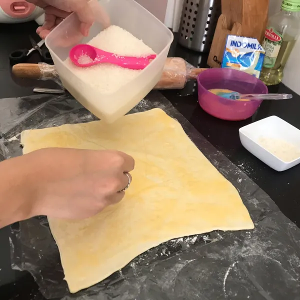 Oleskan telur dan skm tadi di permukaan pastry nya, lalu taburi gula diatasnya sesuai selera.