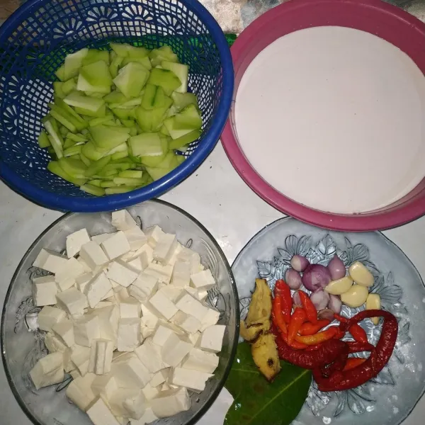 Siapkan terlebih dahulu santan, labu siam yang sudah di iris tipis, tahu putih yang sudah di potong dadu, kemudian bawang merah, bawang putih, lengkuas, daun salam, cabe merah, dan cabe rawit.