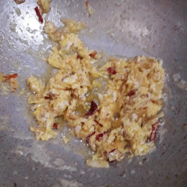 Masukkan telur ayam, aduk-aduk sampai tercampur dengan bumbu dan berbulir kasar.