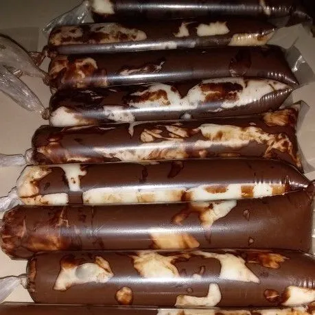 Saring adonan es untuk menghilangkan gumpalan lemak susu, pastikan adonan es sudah dingin. Tuang ke dalam plastik es mambo gunakan corong, kemudian ikat kencang dan masukkan ke dalam freezer hingga beku.