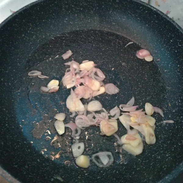Iris-iris bawang putih dan bawang merah, panaskan pan beri minyak goreng lalu tumis bawang merah dan bawang putih sampai wangi.