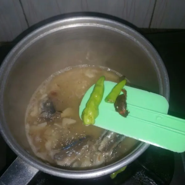 Masukkan cabe rawit dan asam jawa, aduk rata.