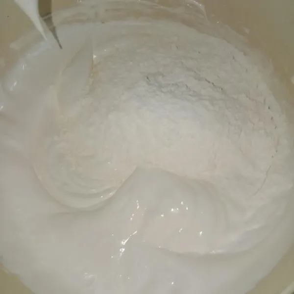 Setelah ngembang berjejak tambahkan tepung terigu dan baking powder, aduk hingga dengan mixer kecepatan rendah.