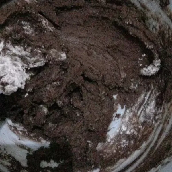 Tambahkan tepung terigu sedikit demi sedikit dan baking powder, aduk hingga adonan bisa dibentuk.