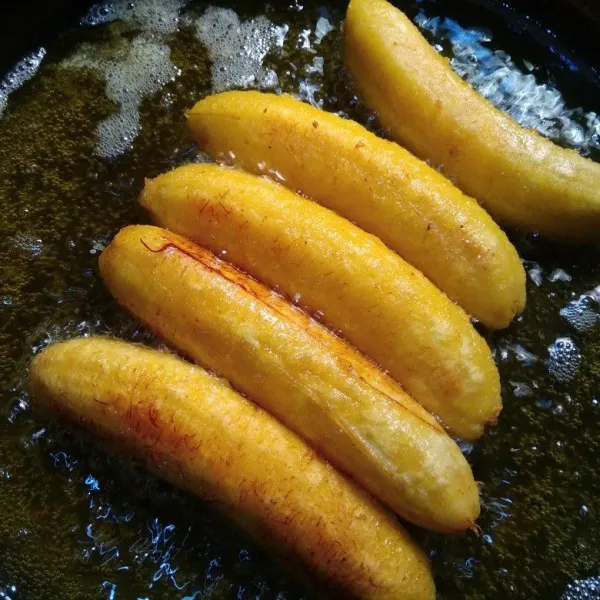 Goreng pisang dengan menggunakan api sedang sambil sesekali di bolak-balik supaya matang merata. Setelah matang, angkat dan tiriskan pisang.