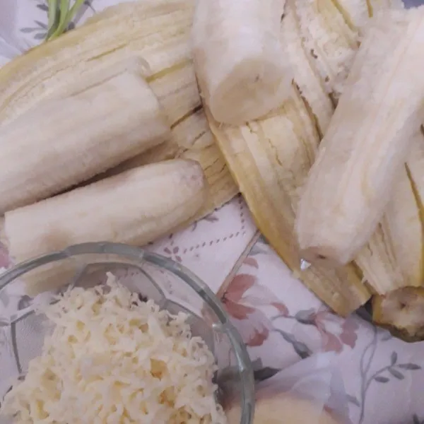 Siapkan bahan, kupas pisang dan belah menjadi 2 bagian serta parut keju cheddar.