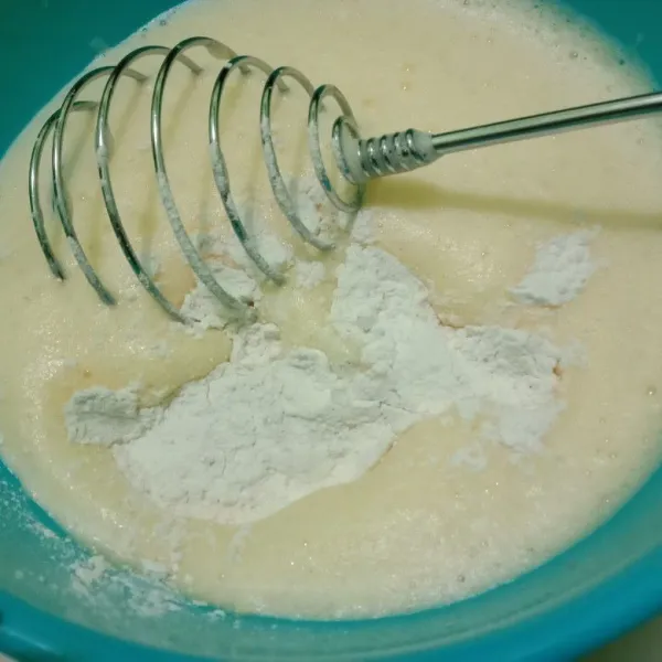 Masukkan tepung yang sudah disangrai ke dalam telur lalu aduk perlahan.