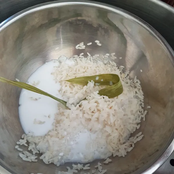 Setelah beras ketan setengah matang, matikan api atau angkat dari kukusan kemudian tambahkan santan dan garam. Aduk rata dan biarkan hingga santan terserap.