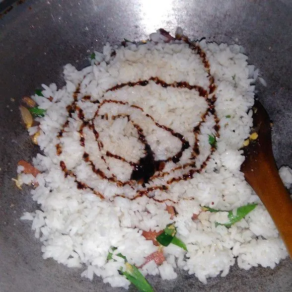 Masukkan nasi aduk hingga rata kemudian tambahkan kecap, lada, garam, dan penyedap rasa.