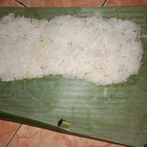 Siapkan daun pisang lalu pipihkan beras ketan diatas daun pisang.