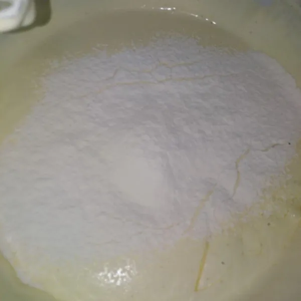 Masukkan susu kental manis, tepung terigu, bersama baking powder sedikit demi sedikit sambil diayak, mixer sampai rata.