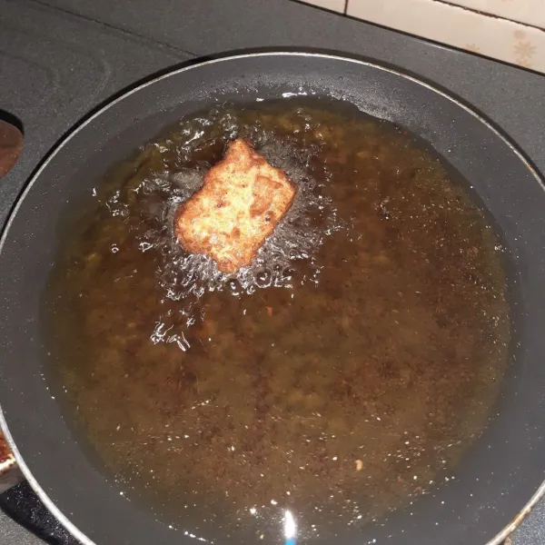 Panaskan minyak, lalu goreng adonan tempe hingga kuning keemasan. Angkat dan tiriskann.