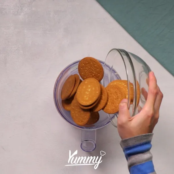 Hancurkan biskuit marie menggunakan food processor, kemudian tambahkan mentega tawar cair, aduk rata. Sisihkan.