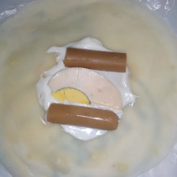Bentuk adonan sampai habis, lalu isi kulit adonan dengan mayonaise, sosis, dan telur rebus.
