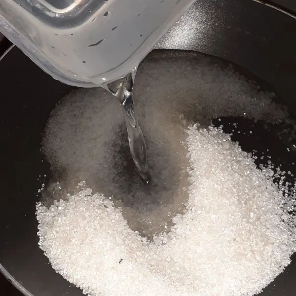 Larutan gula: panaskan panci, masukkan gula dan air lalu aduk hingga rata.