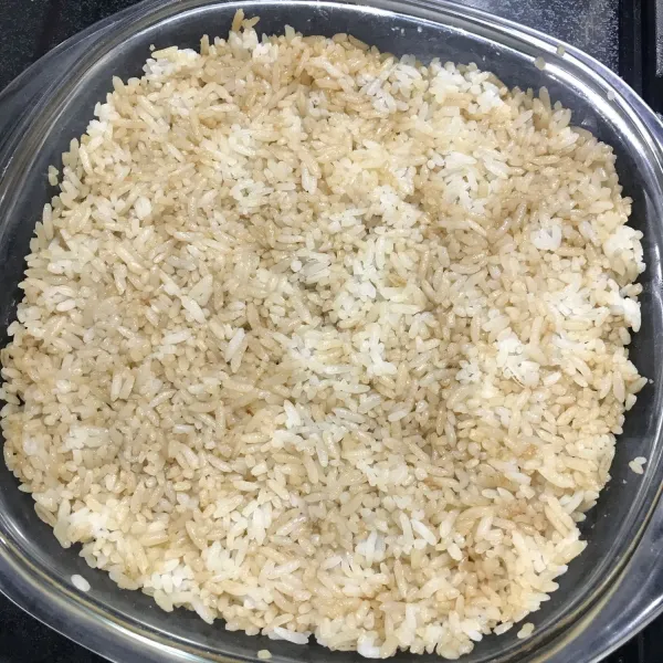 Campurkan nasi dan kecap secukupnya sampai rata dan ratakan di wadah tahan panas atau bisa menggunakan cup aluminium foil.