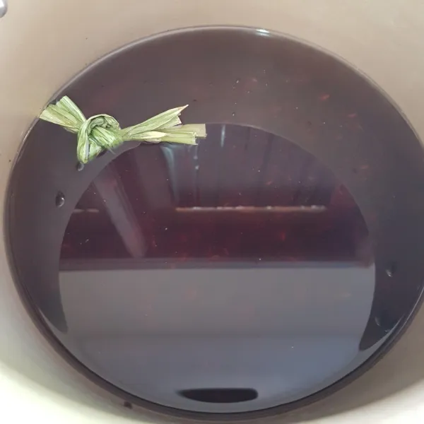 Siapkan panci, masukkan ketan hitam,air, dan daun pandan lalu aduk rata.