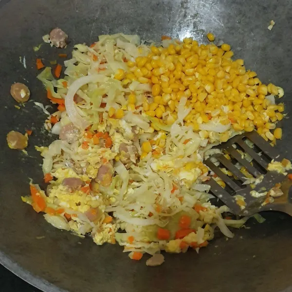 Lalu masukan jagung, wortel, ayam, dan kol. Aduk-aduk lagi.