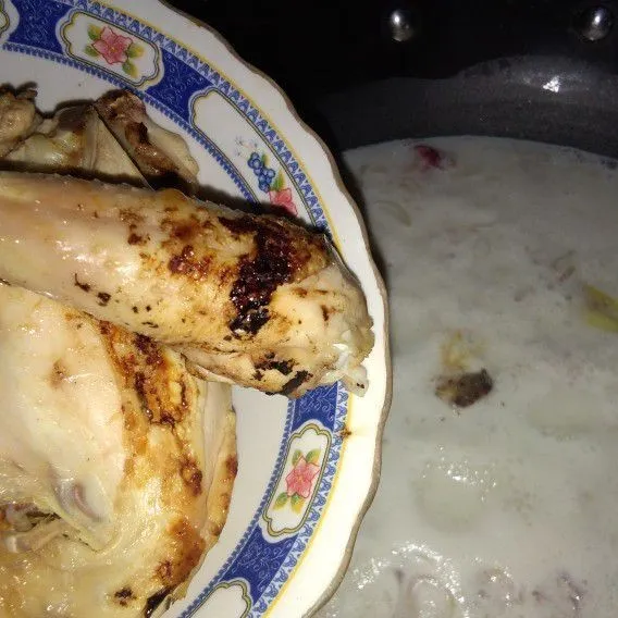 Setelah mendidih, masukkan ayam yang sudah di panggang. Masak sampai santan agak menyusut.