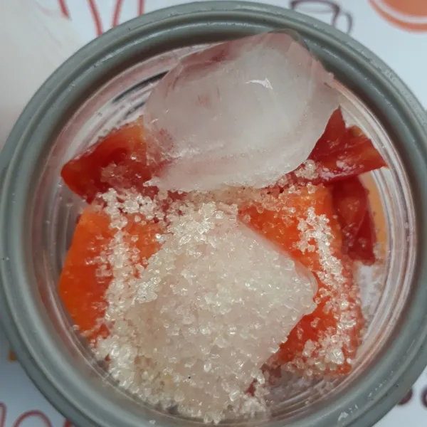 Masukkan pepaya, tomat, gula pasir, dan es batu ke dalam blender. Blender hingga lembut.